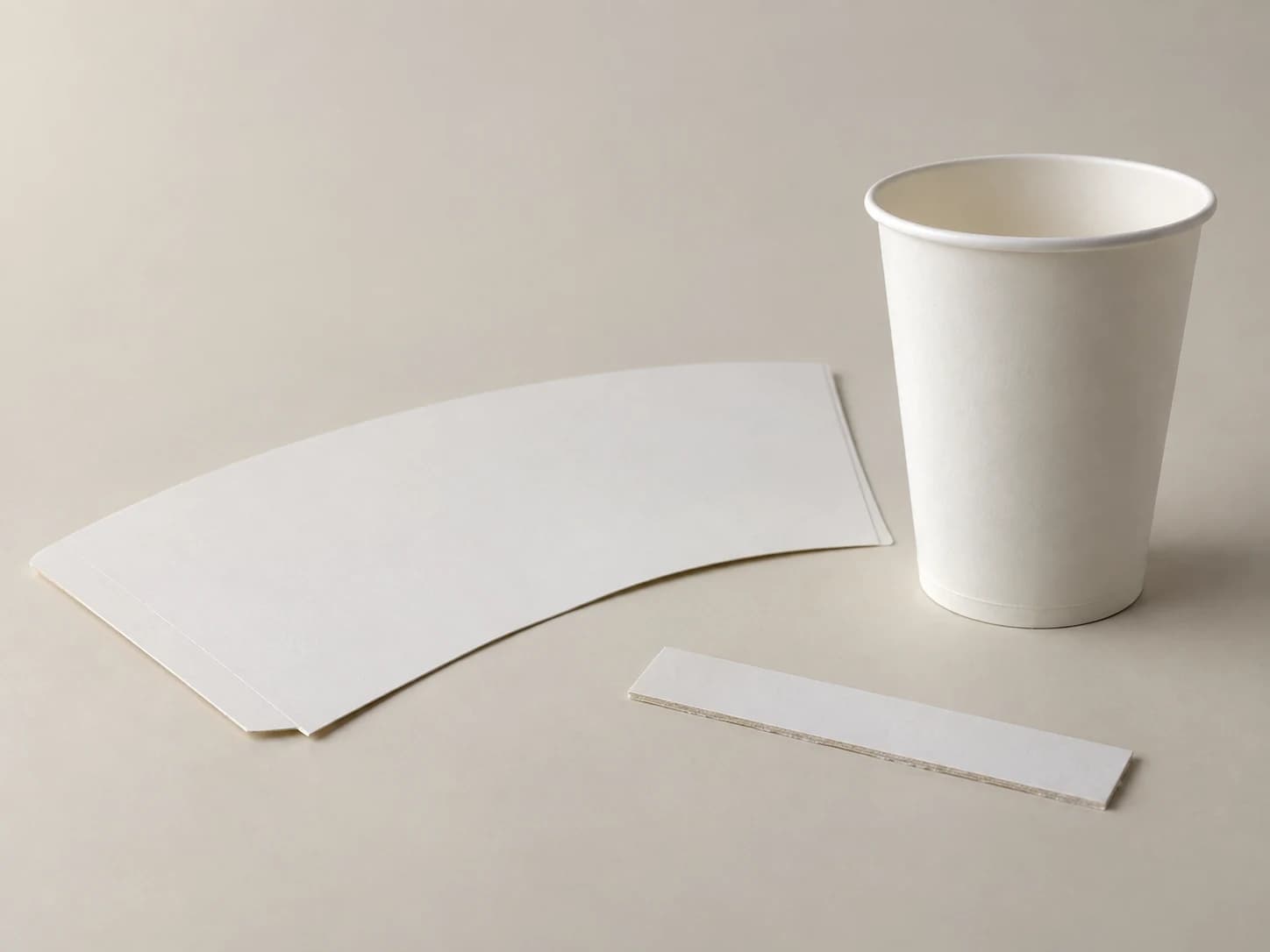 Vaso de cartulina junto a muestras planas del material